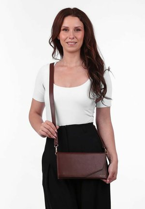 Hnědá kožená crossbody taška s hladkou texturou, obdélníkovým tvarem a jemně zkoseným designem. Obsahuje odnímatelný popruh a akcent v podobě loga.