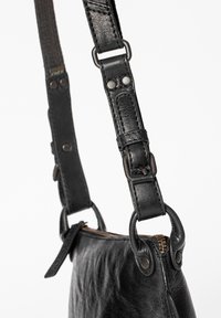 Svart läderhandväska med texturerad yta, försedd med avtagbart axelband, metallbeslag och dragkedjestängning.