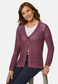 Strickjacke in tiefem Pink mit offenem Gewebemuster, langen Ärmeln und einem einzigen Knopfverschluss am V-Ausschnitt. Fest strukturierte Unterlage.