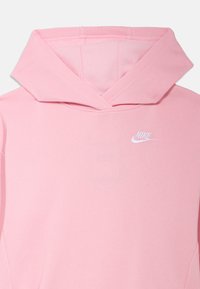 Gaiši rozā Nike džemperis ar striķa kapuci, kuram uzkrāsots balts Nike logotips uz krūšu daļas. Mīksta auduma ar gludu tekstūru.