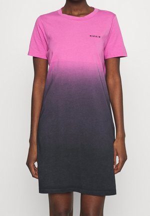 Sukienka z krótkim rękawem w gradient kolorów od różowego do czarnego, z okrągłym dekoltem i małym logo "NIKKIE" na lewej górnej części klatki piersiowej, noszona przez stojącą osobę.