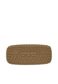 Bruine Crocs voetbed met een gestructureerd oppervlak, voorzien van een profielpatroon en een reliëflogo. Rechthoekige vorm met afgeronde hoeken.
