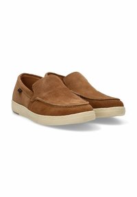 Zapatos marrones de ante tipo slip-on con punta redondeada, costuras en contraste y suela de goma beige. Textura suave con un detalle mínimo.