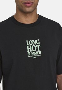 Czarny bawełniany t-shirt z jasnoniebieską grafiką, na której widnieje napis "DŁUGIE GORĄCE LATO" oraz "Santa Monica Beach Kalifornia USA."