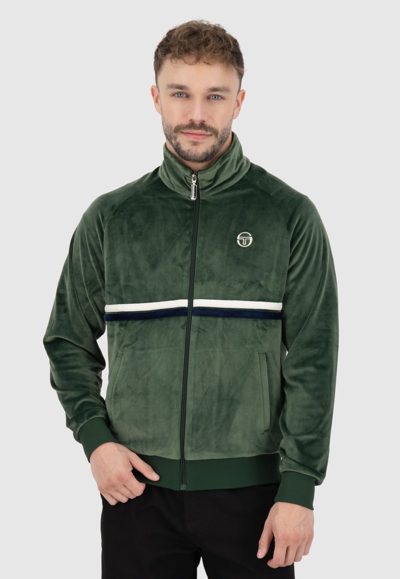Giacca in velour verde con zip, colletto alto, striscia orizzontale bianca e blu, tasche con zip e logo sul petto.