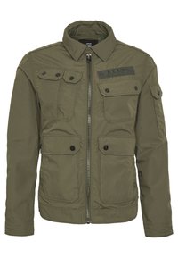 Olivgrön jacka med dragkedja framtill, långa ärmar, flera fackfickor och en slät yta; har en rektangulär axelpatch.