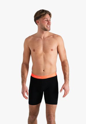 Schwarze Boxer-Shorts mit einem elastischen Bund, der ein oranges "HAPPY SHORTS"-Logo trägt. Glatte Textur und figurschnittige Passform.