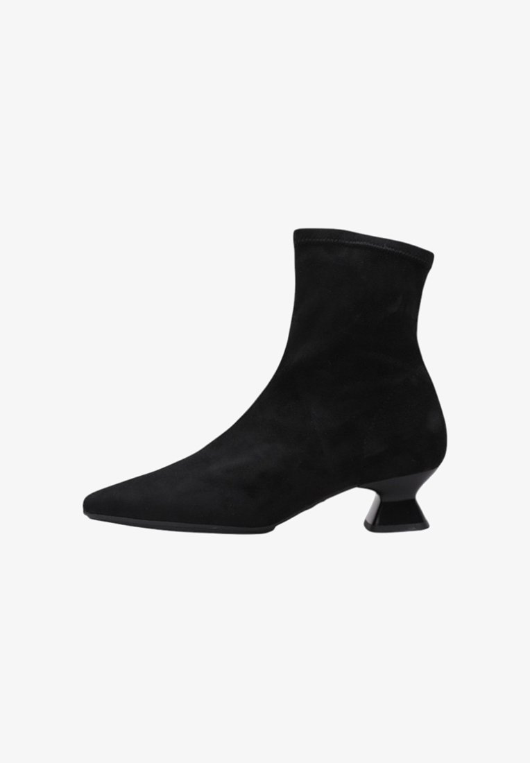 Black suede ankle boot with a pointed toe and a unique block heel. Smooth texture with a seamless upper design.
