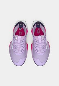 Baskets de sport violettes avec accents roses, tige texturée et fermeture à lacets. Caractéristiques d'une languette de tirage et d'un logo sur la semelle intérieure et sur le côté.