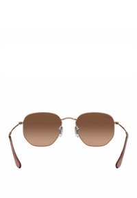 Gafas de sol con degradado marrón, de marco octagonal, con varillas metálicas finas y almohadillas nasales transparentes. El marco presenta un acabado en oro rosa.