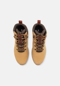 Brown suede hiking boots with gold laces, featuring a padded collar, red accents, and a textured rubber sole. Top-down view.