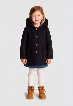 Navyblauwe gewatteerde jas van zachte stof met houten knopen, twee zijzakken, gecombineerd met een spijkerrok en lichtbruine lace-up laarzen.