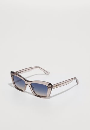 Ochelari de soare cu lentile de tip cat-eye supradimensionate, cu un cadru transparent de culoare gri și lentile negre cu degradé. Prezintă un accent auriu pe braț.