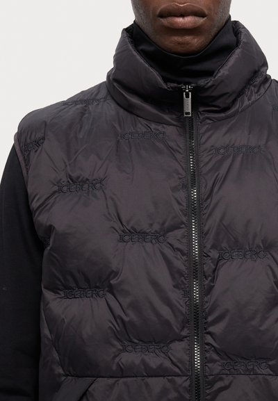 Μαύρο γιλέκο με φουσκωτό σχέδιο, χαρακτηριστικό ψηλό γιακά, κλείσιμο με φερμουάρ και ανάγλυφο λογότυπο "ICEBERG" σε όλη την επιφάνεια, κατασκευασμένο από λείο, υφασμένο ύφασμα.