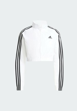 Bijela kratka Adidas trenirka s punim patentnim zatvaračem, crnim tri prugama duž rukava i Adidasovim logotipom na lijevoj strani prsa.