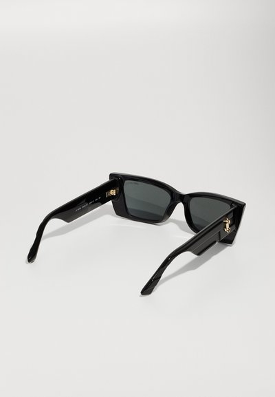 Black sunglasses with a chunky rectangular frame, gray tinted lenses, and gold hardware accents on the side. Smooth, glossy finish.