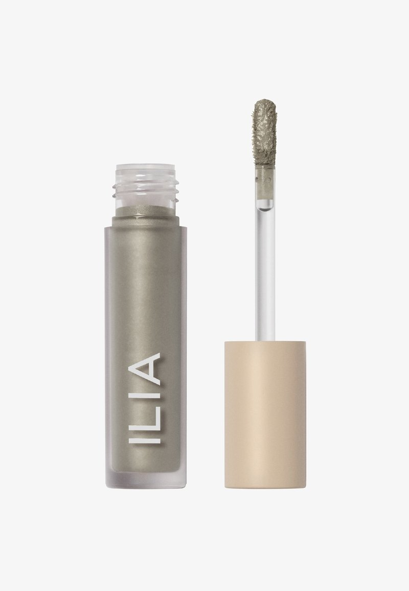 Åbnet tube med skinnende grå cremet øjenskygge med beige låg og applikator dækket af produkt.