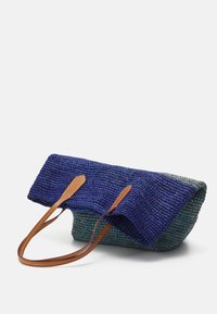 Fållad handväska med blå och grön textur, med bruna läderremmar. Designen har en vikbar topp för stängning och en strukturerad form.