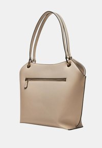 Bolso tote de imitación de cuero beige con dos asas largas, bolsillo exterior con cremallera, textura suave y bordes contrastantes en negro.