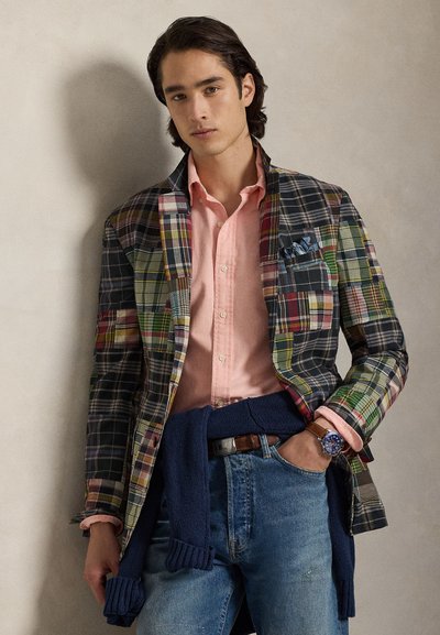 Svārks ar daudzkrāsainiem kvadrātiem, gaiši rozā krekls, tumši zils džemperis, sasiets viduklī, zils pulkstenis, džinsi. Teksturēts audums, dažādi raksti.