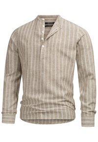 Chemise beige à manches longues avec rayures verticales blanches, col rond, patte de boutonnage demi-longueur et logo brodé subtil sur la poitrine.