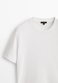 Maglietta bianca in cotone con scollo a girocollo, maniche corte e texture liscia. Etichette visibili all'interno del colletto. Design semplice, senza motivi.