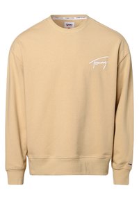 Beżowy sweter z bawełny, z okrągłym dekoltem, ściągaczami u rękawów i małym białym logotypem na piersi. Miękka tekstura i casualowy design.