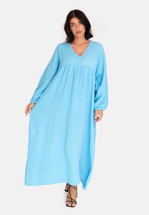 Lungo abito maxi fluente in blu chiaro, realizzato in tessuto testurizzato. Presenta un collo a V e maniche lunghe, con vestibilità ampia e vita arricciata.