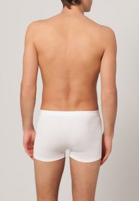 Boxer briefs bianchi in cotone con design aderente e morbida fascia in vita, che mostrano una texture liscia e superficie semplice dal retro.