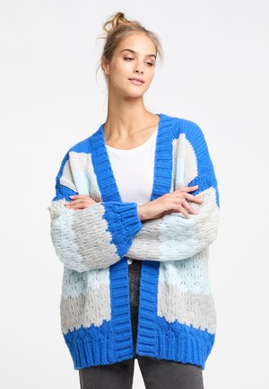 Paksu neulecardigan, jossa on sinisen, vaaleansinisen ja harmaan värin lohkoja. Auki oleva etuosa, pitkät hihat, teksturoitu kangas ja ribbitut hihansuut.