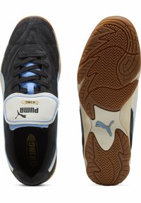 Sapatilhas pretas de camurça da Puma com detalhes em azul claro e uma fita branca. Apresentam uma sola de borracha de gengibre com padrão de piso. Design atlético clássico.