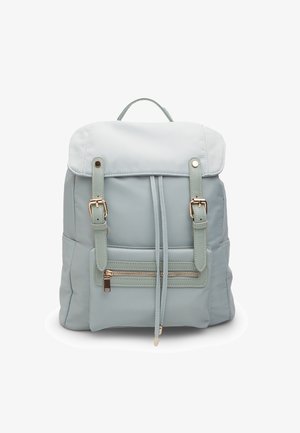 Zaino azzurro chiaro realizzato in materiale sintetico con una superficie morbida, dotato di spallacci regolabili, una tasca frontale con zip e una chiusura a pattina.