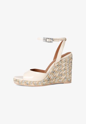 Sandale compensée en cuir verni beige avec plateforme en jute tressé, bout ouvert, bride à la cheville et boucle argentée décorative.