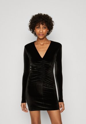 Abito in velluto nero con maniche lunghe, scollatura a V profonda e dettaglio arricciato nella parte anteriore. Design aderente e raffinato che esalta la silhouette.