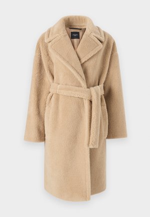 Cappotto beige, peloso, con collo a scialle, maniche lunghe e una cintura annodata. Presenta una parte anteriore aperta e un tessuto morbido e testurizzato.