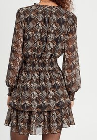 Robes à motif floral sombre avec manches longues, taille élastique, ourlet à volants en couches et tissu léger semi-transparent. Les couleurs incluent le brun, le beige et le noir.