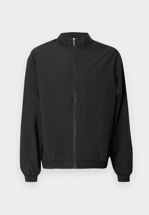 Mustast kerge kangast bomber-jakk; esiosa tõmblukk, kõrge krae, elastsed mansetid ja vormitud ääreosa. Lihtne ja sujuv disain.