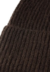 Braune Strickmütze mit gerippter Textur aus weicher Wolle. Das Design verfügt über horizontale Rillen und eine subtile, fuzzy Oberfläche.