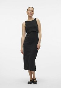 Must värv, ilma varrukateta midi kleit, millel on vormitud bodice ja külgauk. Valmistatud pehmest ja siledast kangast, millel on lihtne ja puhas disain.