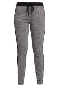 Svarta och vita rutiga joggerbyxor med svart elastisk midja, dragsko och svarta detaljer på sidorna. Stretchigt material, slim fit.