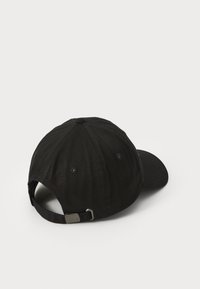 Svart baseballcaps laget av stoff med seks-paneldesign, justerbar stropp og buet skjerm. Har liten metallisk innretning på stroppen.