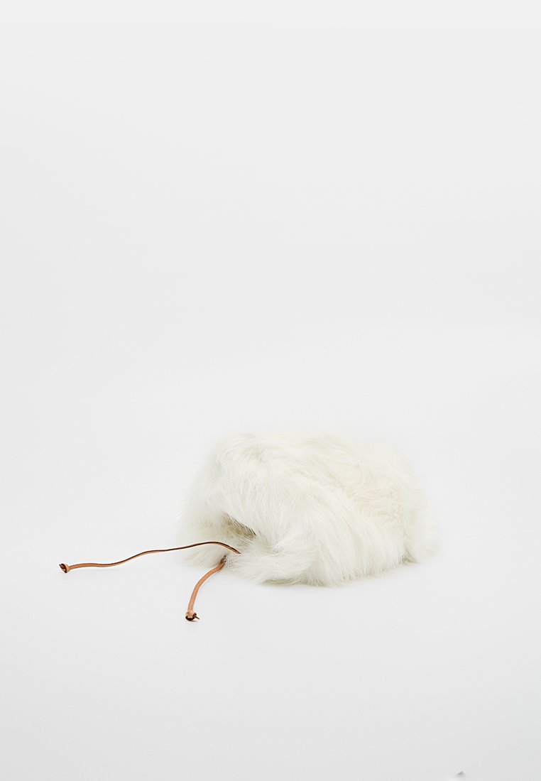 Weißer flauschiger Winterhut mit Ohrenklappen und braunen Lederbändern auf weißem Hintergrund.