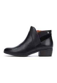 Bottine noire en cuir avec un bout rond, un petit talon empilé et une sangle d'accent en daim. Fermeture à glissière sur le côté et petit détail métallique.