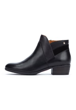 Bottine noire en cuir avec un bout rond, un petit talon empilé et une sangle d'accent en daim. Fermeture à glissière sur le côté et petit détail métallique.