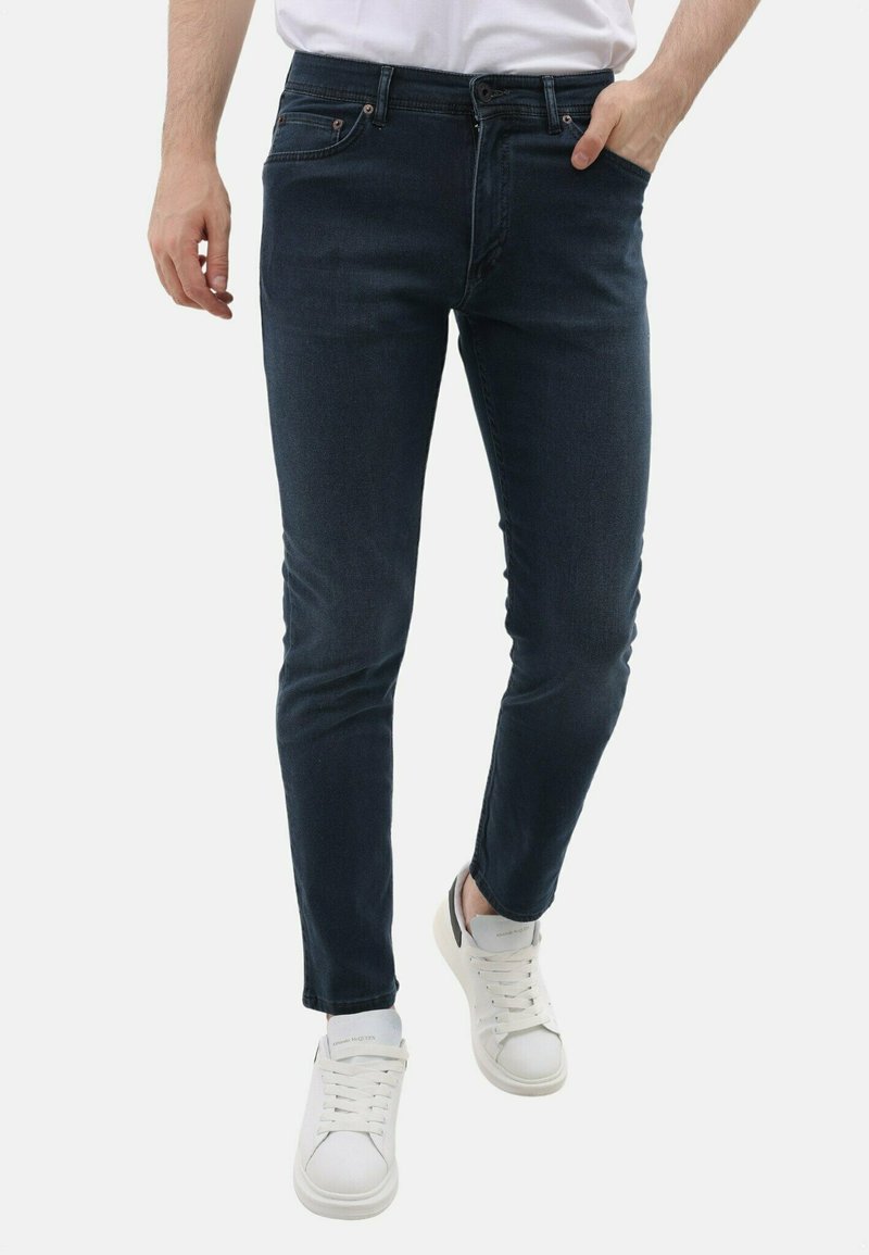 Donkerblauwe slim-fit spijkerbroek van denim, met een vijf-pocket ontwerp, knoopsluiting aan de voorkant en subtiele vervaging langs de benen.