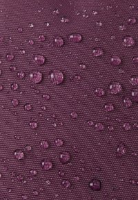 Teksturowana tkanina w ciemnym fioletowym kolorze z kroplami wody na powierzchni, ukazująca cechę wodoodporności. Spójny wzór na całej powierzchni.