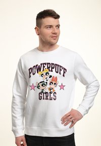 Bílá mikina s barevným grafikou "Powerpuff Girls" a růžovými hvězdnými akcenty. Měkká textura, pohodlný střih, kulatý výstřih, žebrované manžety.