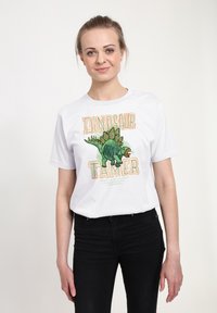 Hvid bomulds T-shirt med et grønt dinosaur grafik og teksten "Dinosaur Tamer" i orange. Enkel design med korte ærmer.
