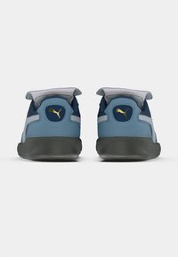 Sinine ja tumesinine sportjalatsite paar hallide aktsentidega, mis on varustatud tekstureeritud kummist tallaga ja kuldse logoga kannaosas. Ümar design koos pehmendatud kraega.