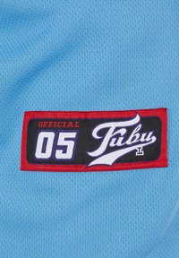 Šviesiai mėlyna akyto audinio medžiaga su juoda, raudona ir balta etikete, kurioje užrašyta "OFFICIAL 05" ir "Fubu" stilizuotu šriftu.